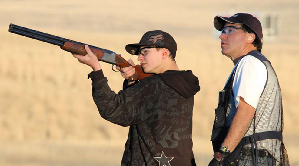 shotguns-for-kids-nssf - Popular Ammo A child shooting a shotgun being instructed by an adult